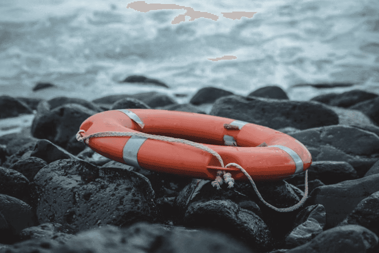 Lifebuoy ring on wet coastal rocks
