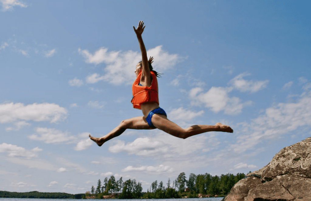 Person Jumping Into Water Wearing Life Jacket