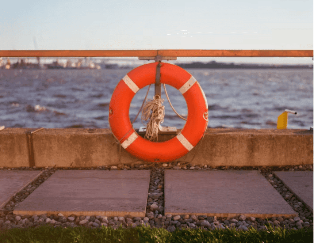 Life Buoy Hanging on Riverside Rail at Sunset
