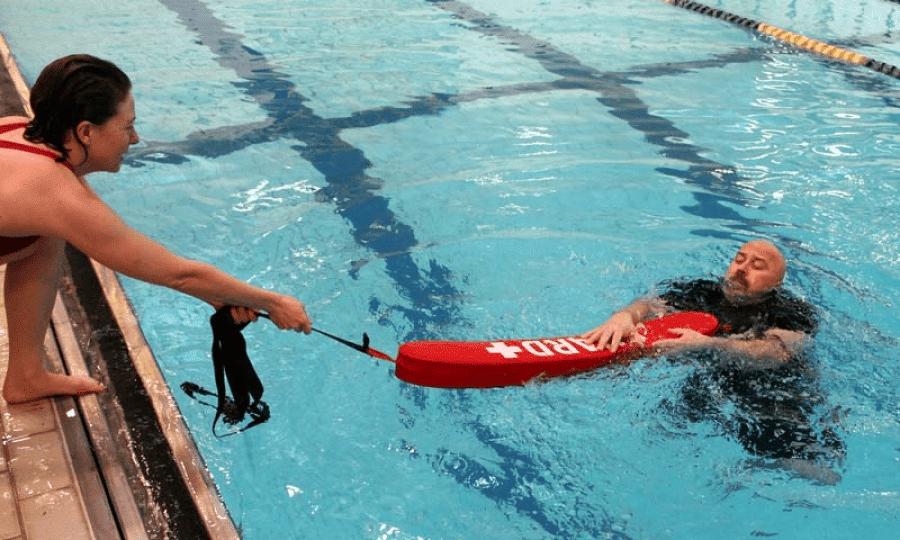 lifeguard stand with rescue tube on sunny pool deck